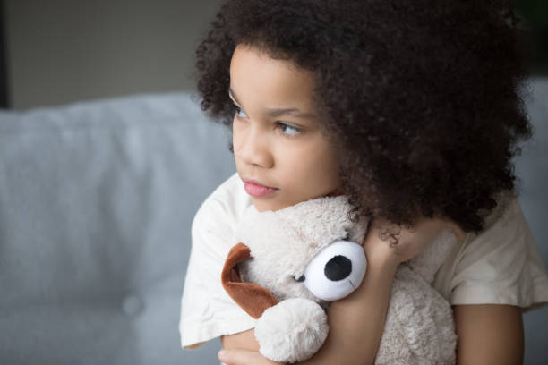 unfortunate stray biracial kid girl embrace stuffed toy looking aside - aside imagens e fotografias de stock