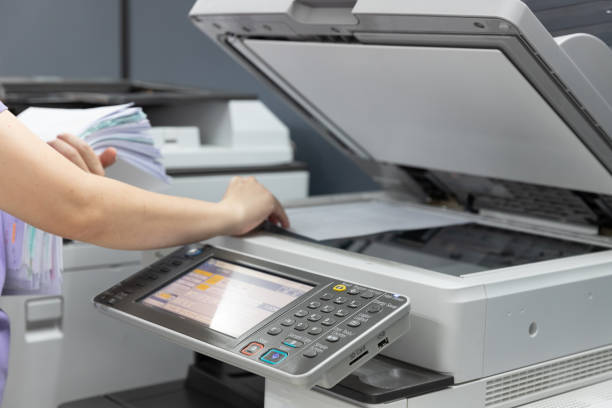 bussinesswoman che utilizza la fotocopiatrice per copiare un mucchio di documenti in ufficio. - inkjet foto e immagini stock