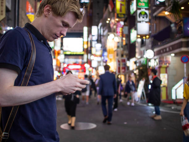 istock A handsome man looking at his phone on a Tokyo street 1153596309