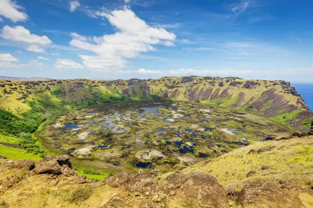 Rano Kau Volcano Crater Lake under blue summer sky. Rano Kau - Rano Kao - is a extinct volcano that forms the southwestern headland of Rapa Nui, Easter Island, Isla de Pascua, Polynesia, Chile.