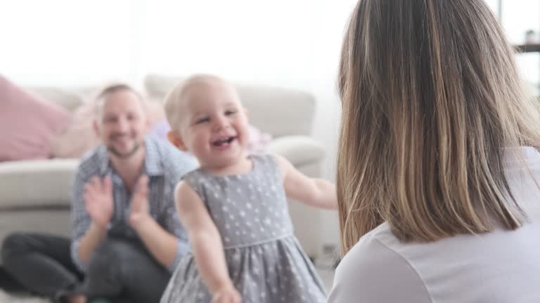 Parents with baby girl learning to walk