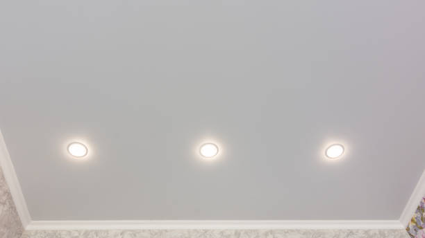 istock Fragment of the stretch ceiling with three spotlights in a row 1153606503