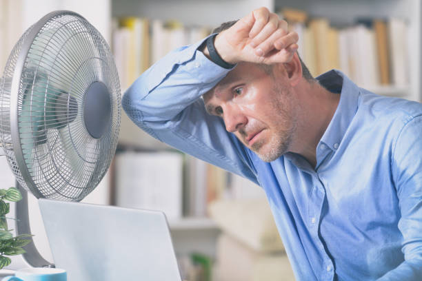 Man suffers from heat in the office or at home stock photo
