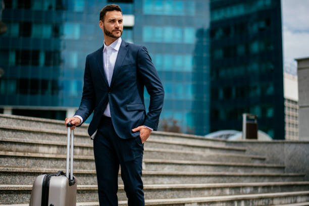 istock Businessman walking outside airport with suitcase 1153608615