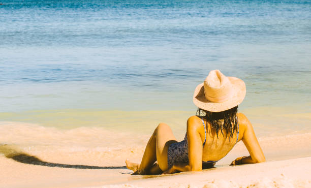 istock Attractive young woman in bikini relaxing on sandy beach. 1153610850