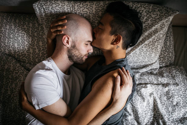 pareja homosexual en la cama - gay man homosexual men kissing fotografías e imágenes de stock