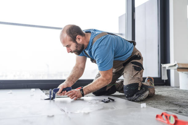 Tile worker placing separators between floor tiles Adult tile mason placing and fixing separators while installing floor tiles kneepad stock pictures, royalty-free photos & images