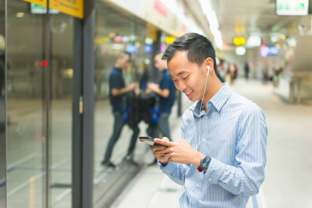 istock Taiwanese young man typing a text message while waiting for metro 1153618457