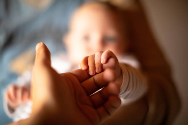 hand hält neugeborenebaby hand - neu stock-fotos und bilder