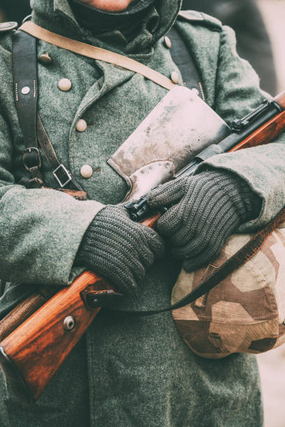 istock Midsection Of Soldier Holding Gun And Hat 1153623220