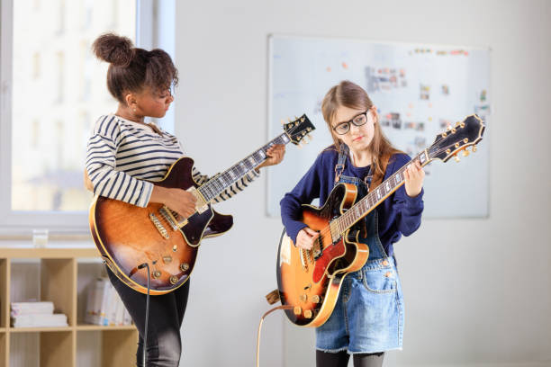 studentessa che impara la chitarra dall'allenatore - guitar child music learning foto e immagini stock