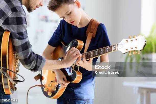 Teenage Boy Learning Electric Guitar From Trainer Stock Photo - Download Image Now - Guitar, Music, Learning