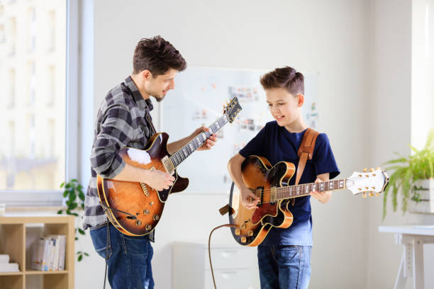 istock Teenage boy learning electric guitar from trainer 1153626419