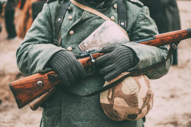 istock Midsection Of Soldier Holding Gun And Hat 1153627179