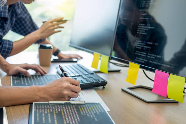 istock Midsection Of Man Using Computer With Colleague At Office 1153627312