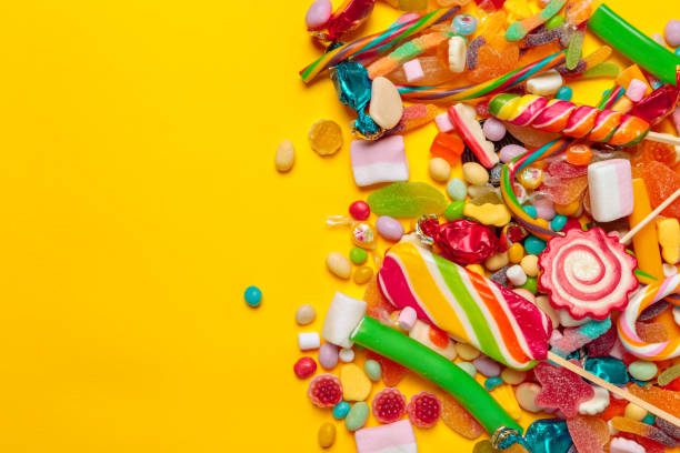 istock colored candies on yellow background 1153632274