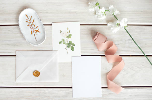 istock Wedding invitation as a decorated letter on a white tablecloth with a flower arrangement. 1153632515