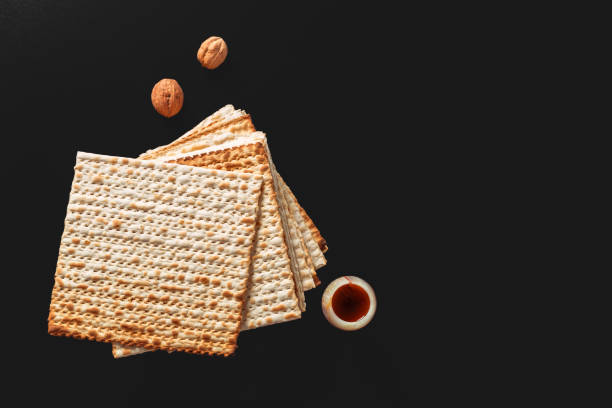 une photo de matsa ou matza pièces sur fond noir. matzah pour les vacances juives de la pâque. emplacement pour le texte, l’espace de copie - seder passover seder plate matzo photos et images de collection