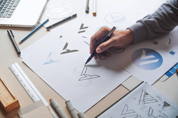 Graphic designer development process drawing sketch design creative Ideas draft Logo product trademark label brand artwork. Graphic designer studio Concept. stock photo