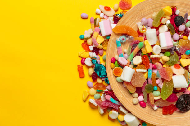 istock colored candies on yellow background 1153633385
