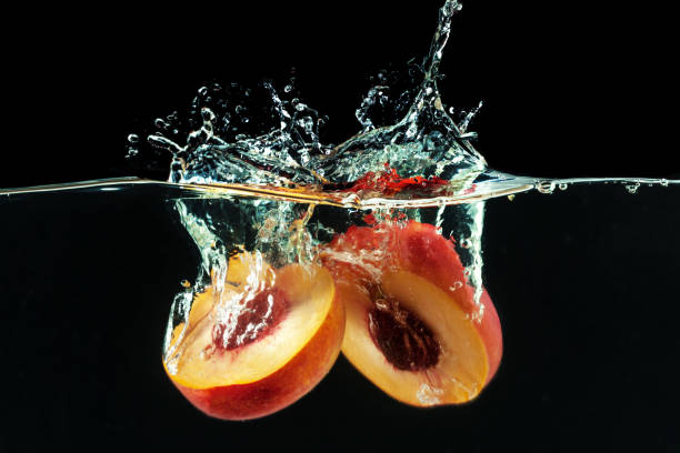 Peach dropped into water with bubbles