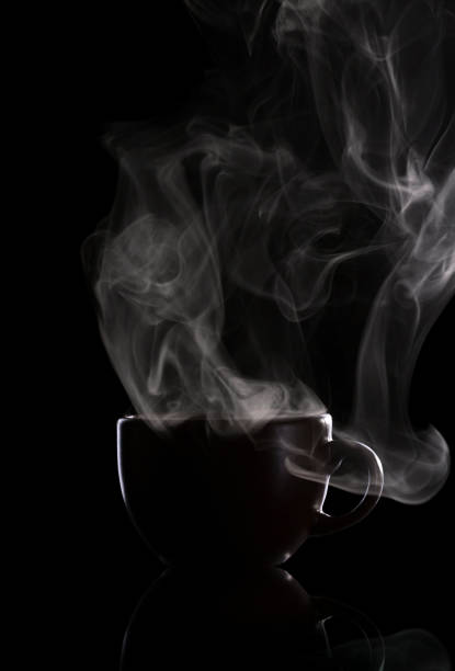 istock Dark cup with hot coffee and steam, isolated on black 1153636435