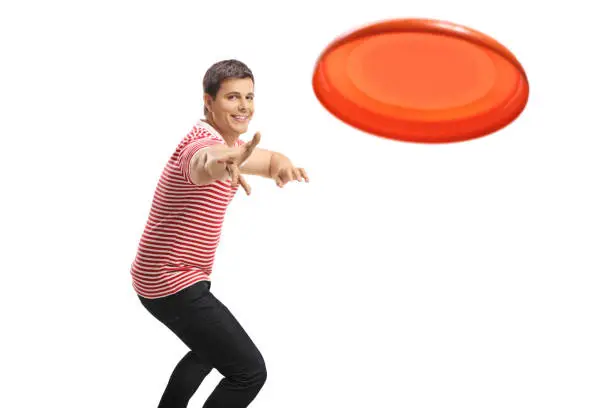 Young handsome guy throwing a frisbee isolated on white background