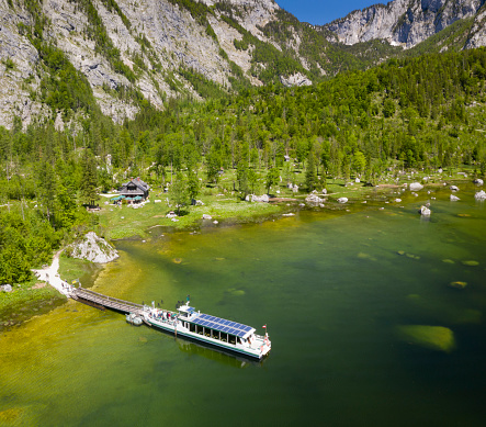 The famous Seewiese in the middle of the Austrian Alps. A new solar powered boat bringing the tourist to this idyllic place by the lake Altaussee, Steiermark, Austria. Aerial Photography. Converted from RAW.