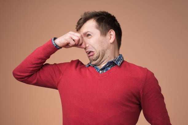 istock Man plugs nose as smells something stink 1153642814