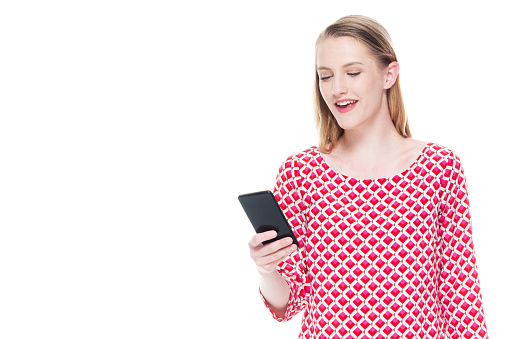 Beautiful young teenage girl wearing a red dress - holding smart phone