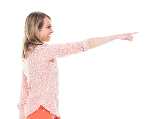 istock Beautiful white female in bright clothes - pointing ahead 1153644312