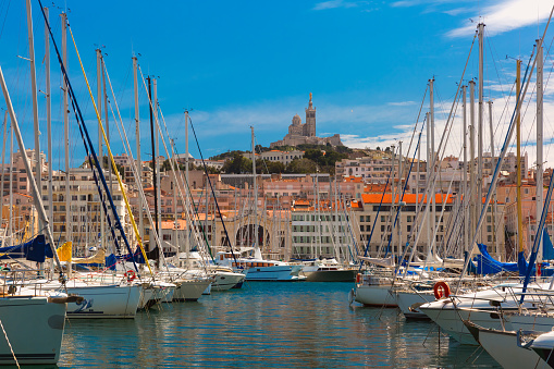 Sunny Old Port and the Basilica of Notre Dame de la Garde on the background, on the hill, Marseille, France