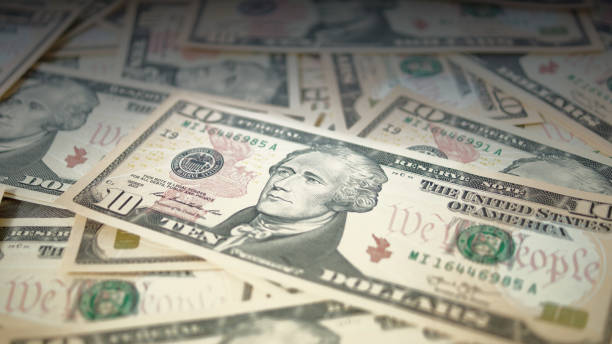 istock Approach to a group of 10 dollar unordered bills. Banknotes background 1153647364