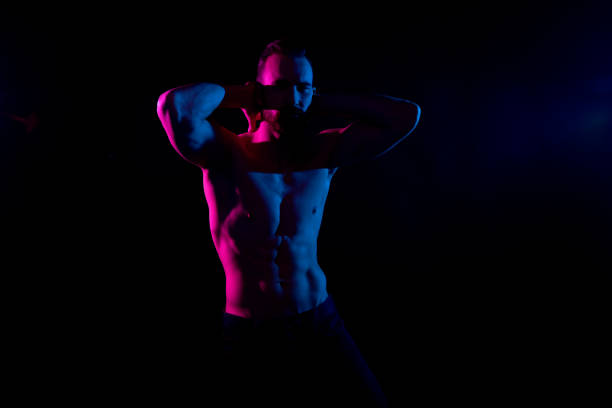istock Sexy shirtless man with gel lighting on black background 1153649801