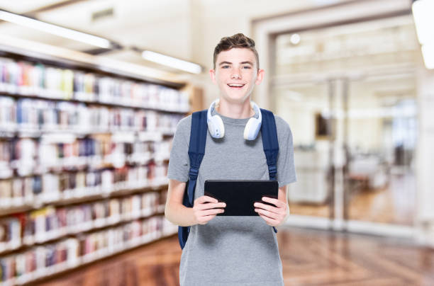 istock 13 year old teenage boy wearing headphone - using digital tablet 1153651029