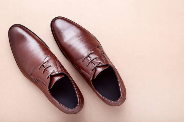 istock Male leather shoes on beige background 1153651378
