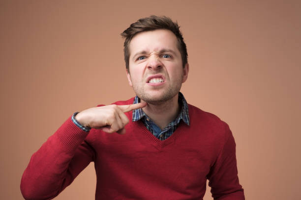 istock man gesturing with index finger at his neck 1153652344