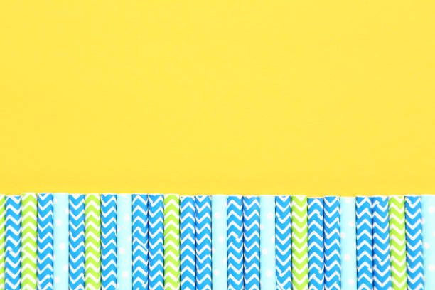 istock Colorful paper straws on yellow background 1153654478