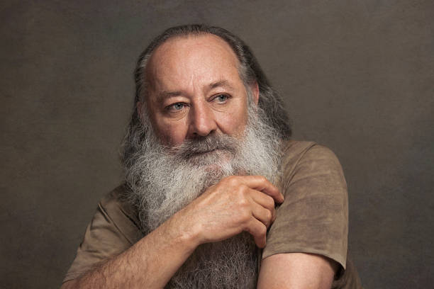 istock old man with a long beard with sadness on a Gray background 1153656510