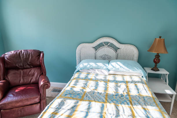 istock New clean bed comforter with wicker rattan headboard table vintage beach blue pillows in bedroom in home house with leather mahogany armchair 1153658165
