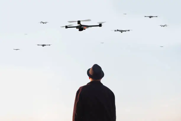 man looking at the sky filled with drones