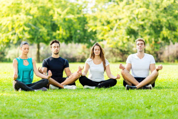 istock Friends meditating in park 1153662491