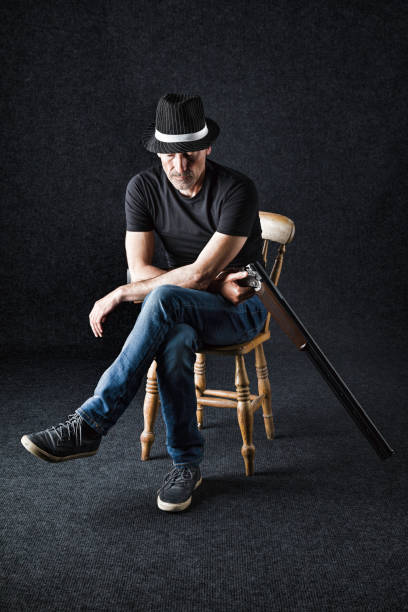 istock Tough wearing a fedora hat and holding a shotgun 1153663515