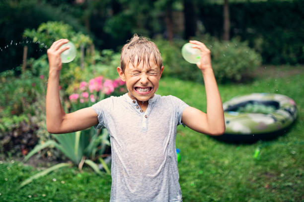 小さな男の子が水風船で頭をはねてし�まう - child balloon outdoors little boys ストックフォトと画像