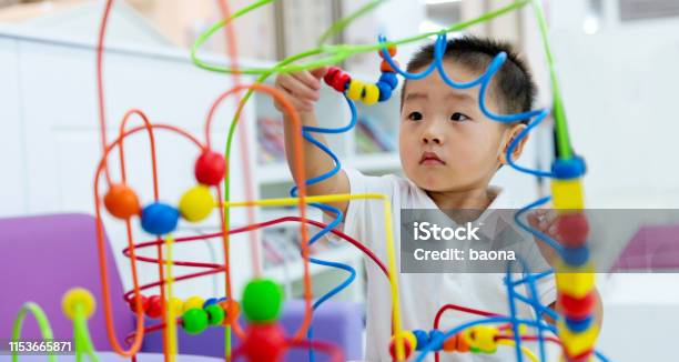 Littl Boy Working On A Puzzle Stock Photo - Download Image Now - Child, Baby - Human Age, Playful