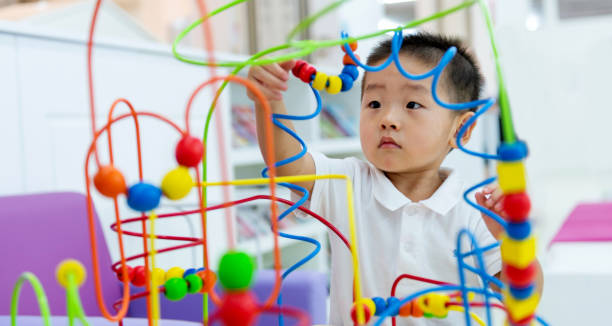 littl boy working on a puzzle - block child play toy imagens e fotografias de stock