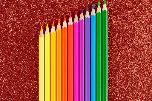 Colored Pencils On Glitter Red Background Stock Photo - Download