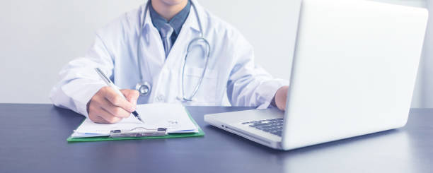istock Doctor working with laptop computer and writing on prescription paperwork,Having Consultation,Medical Pretty working in hospital, Healthcare and medically concept,selective focus 1153671501