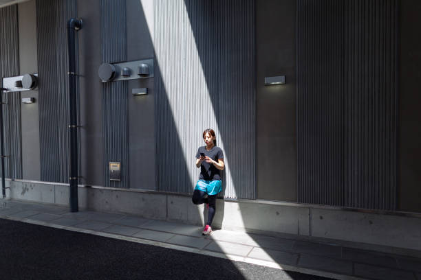 Young female athlete using smart phone in city