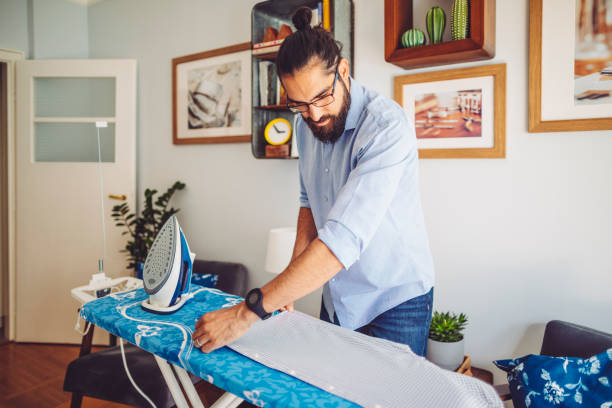istock Young man ironing his shirt 1153674218